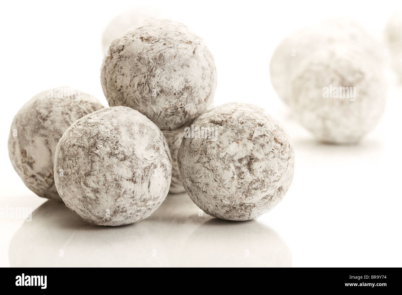 Un peu de sucre en poudre pralines truffe couverte sur fond blanc Banque D'Images