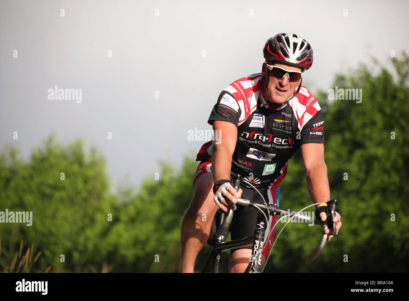Un homme d'âge moyen dans un cycle complet tenue cycliste à travers les  arbres Photo Stock - Alamy