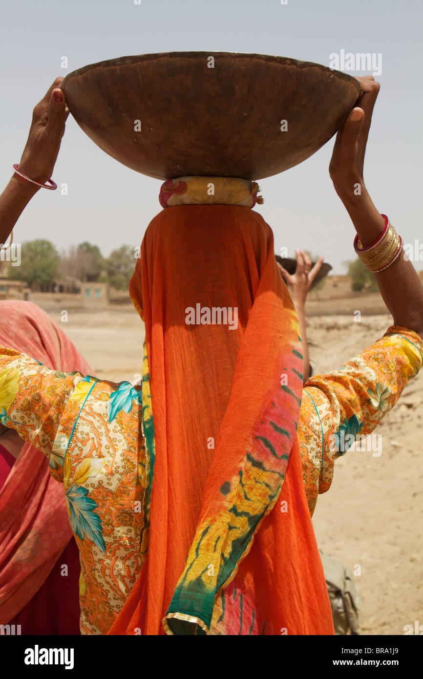 Rajasthan femme de l'arrière avec une assiette sur la tête Banque D'Images