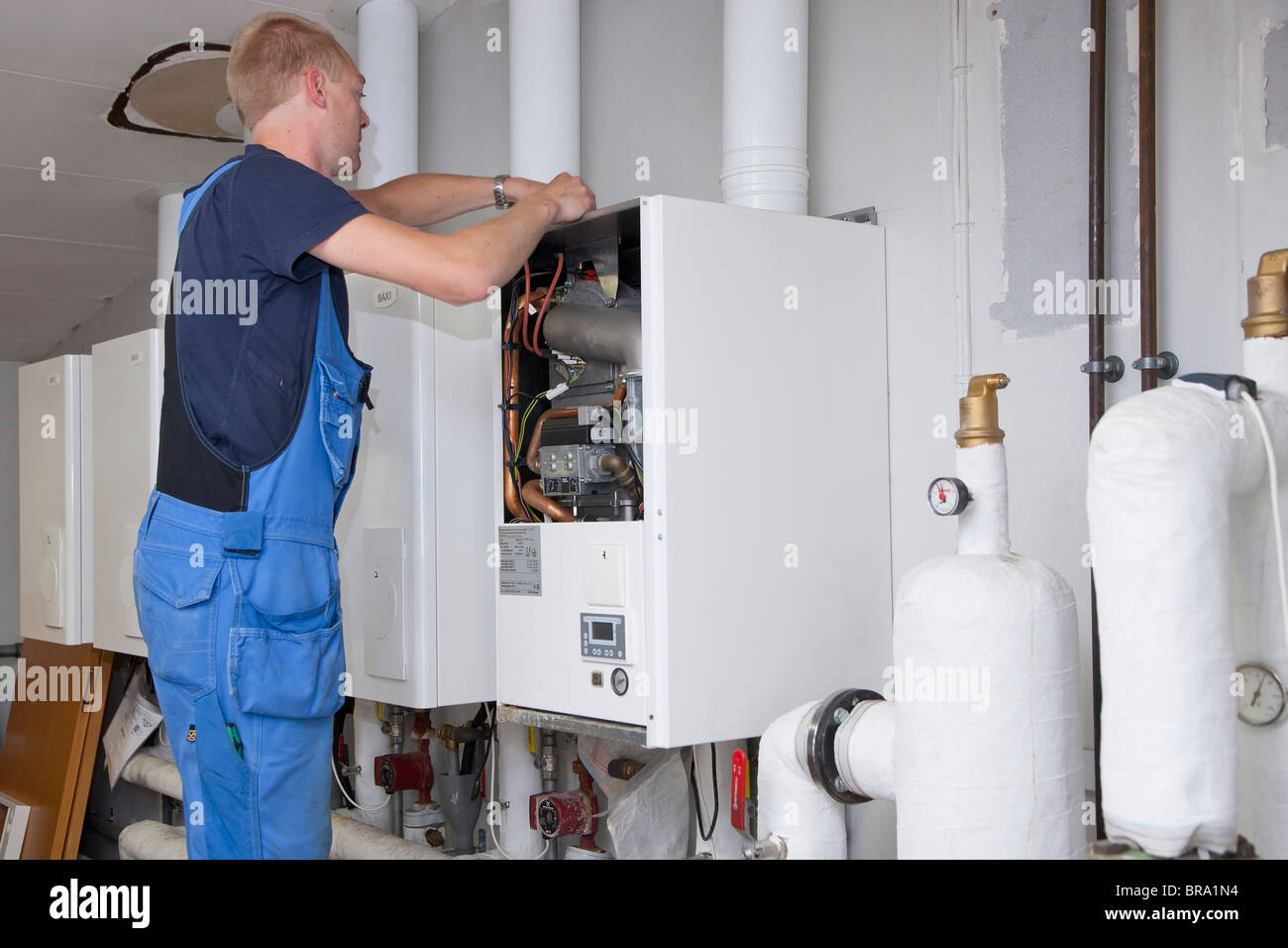 Technicien en chauffage et sanitaire Contrôle et réglage un chauffage au gaz Banque D'Images
