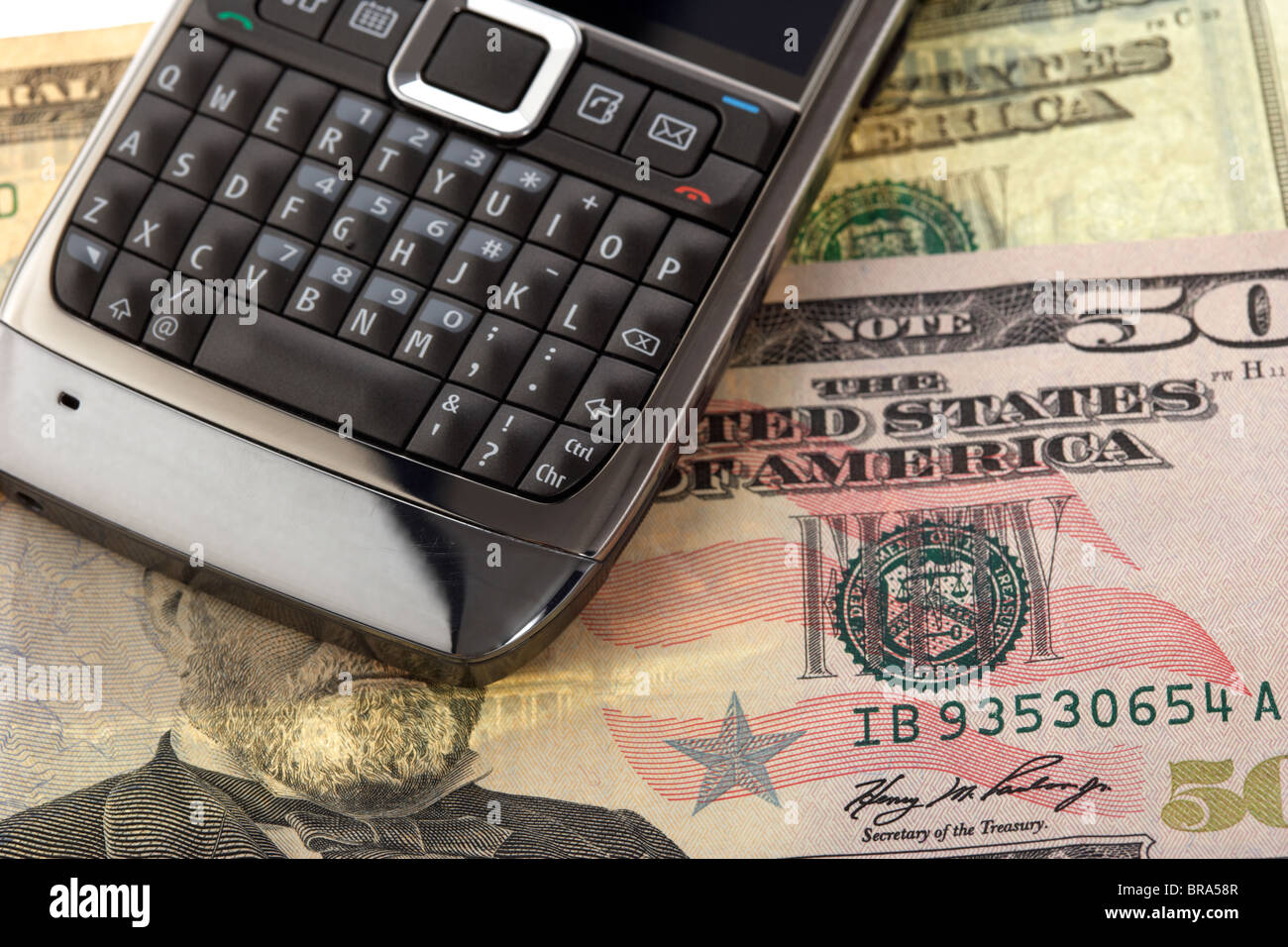 Mobile cell phone smartphone sur un tas de billets en dollars us Banque D'Images