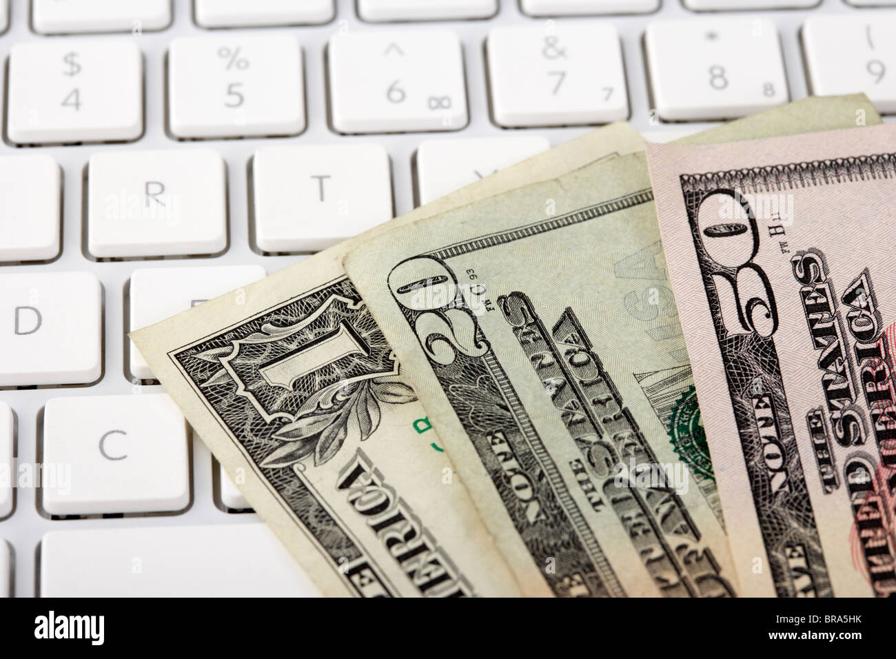 Pile de billets en dollars us sur un clavier d'ordinateur Banque D'Images