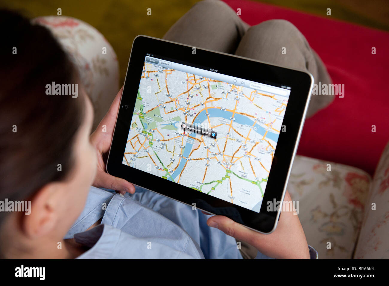 Femme à l'aide de l'application Google Maps sur tablette iPad ordinateur pour regarder la carte de London Banque D'Images