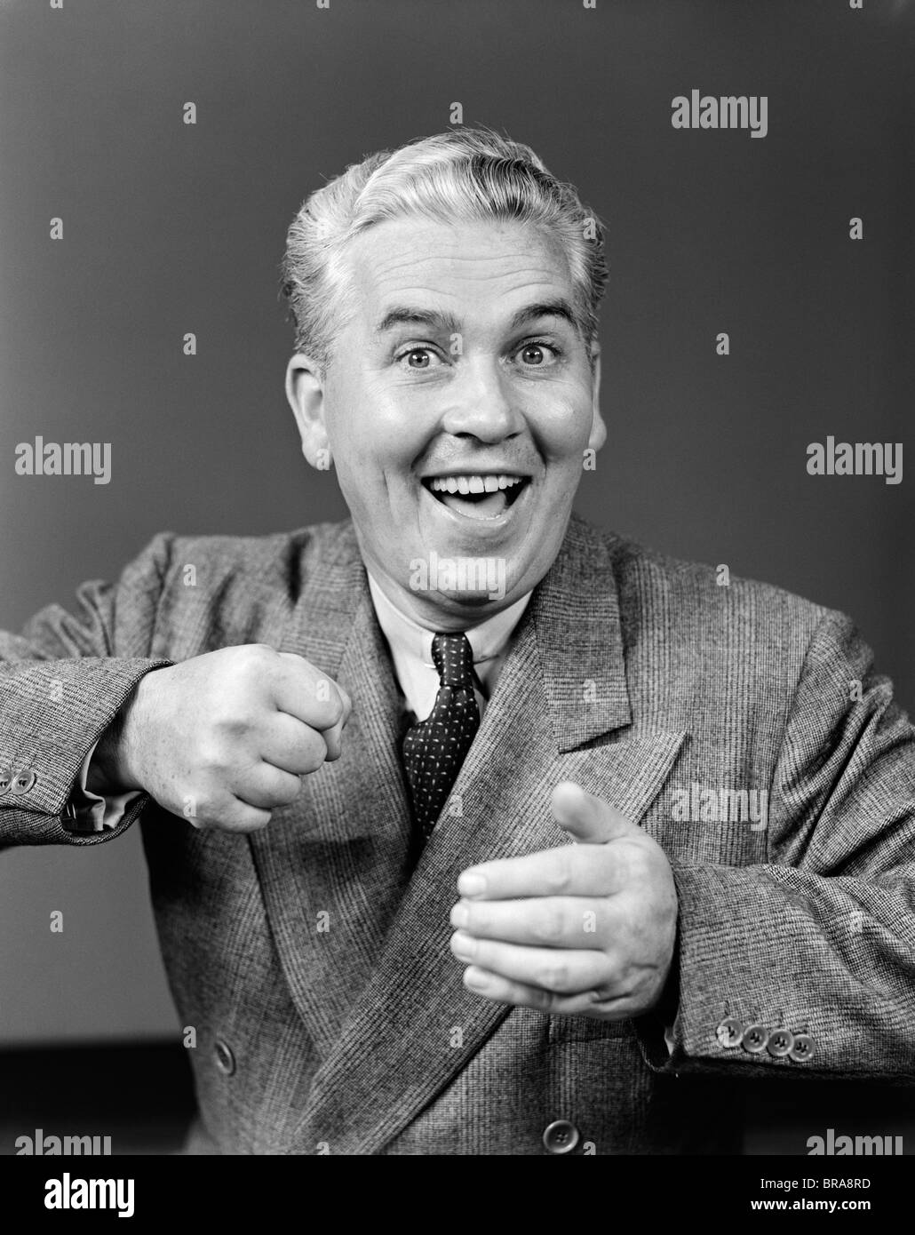 1940 MAN MAKING FIST AND SMILING Banque D'Images