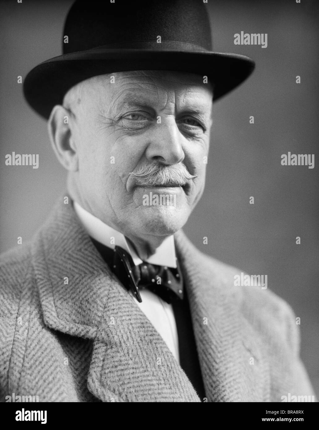 1930 PORTRAIT D'HOMME PLUS ÂGÉ AVEC UNE MOUSTACHE PORTANT UN CHAPEAU MELON ET BOW TIE Banque D'Images