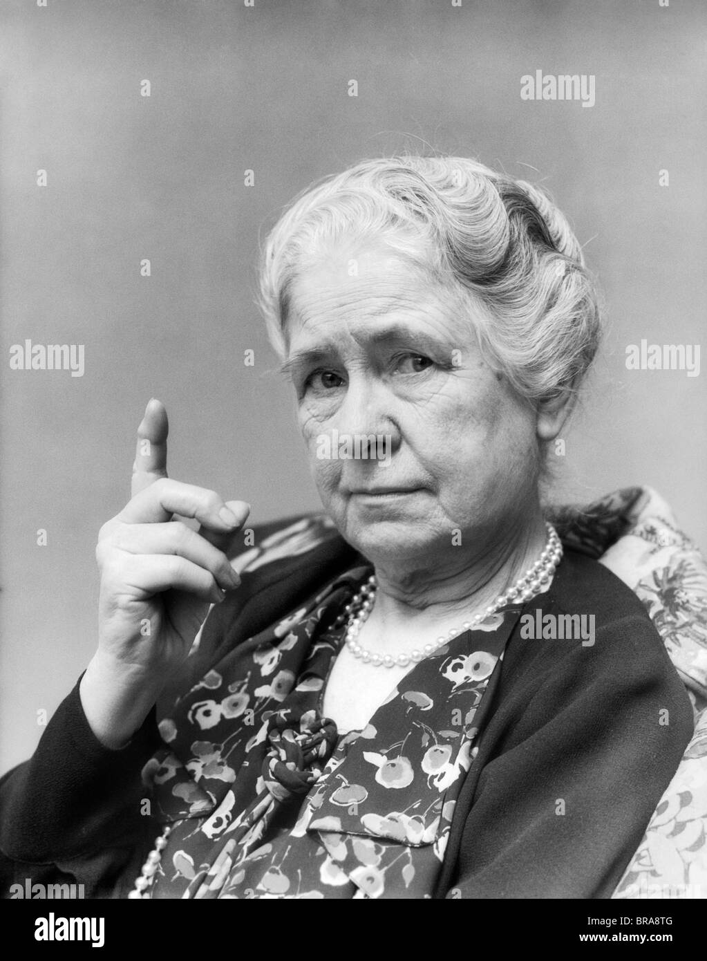 1930 PORTRAIT D'UNE FEMME ÂGÉE AVEC DOIGT SOULEVÉ AU VIEWER Banque D'Images