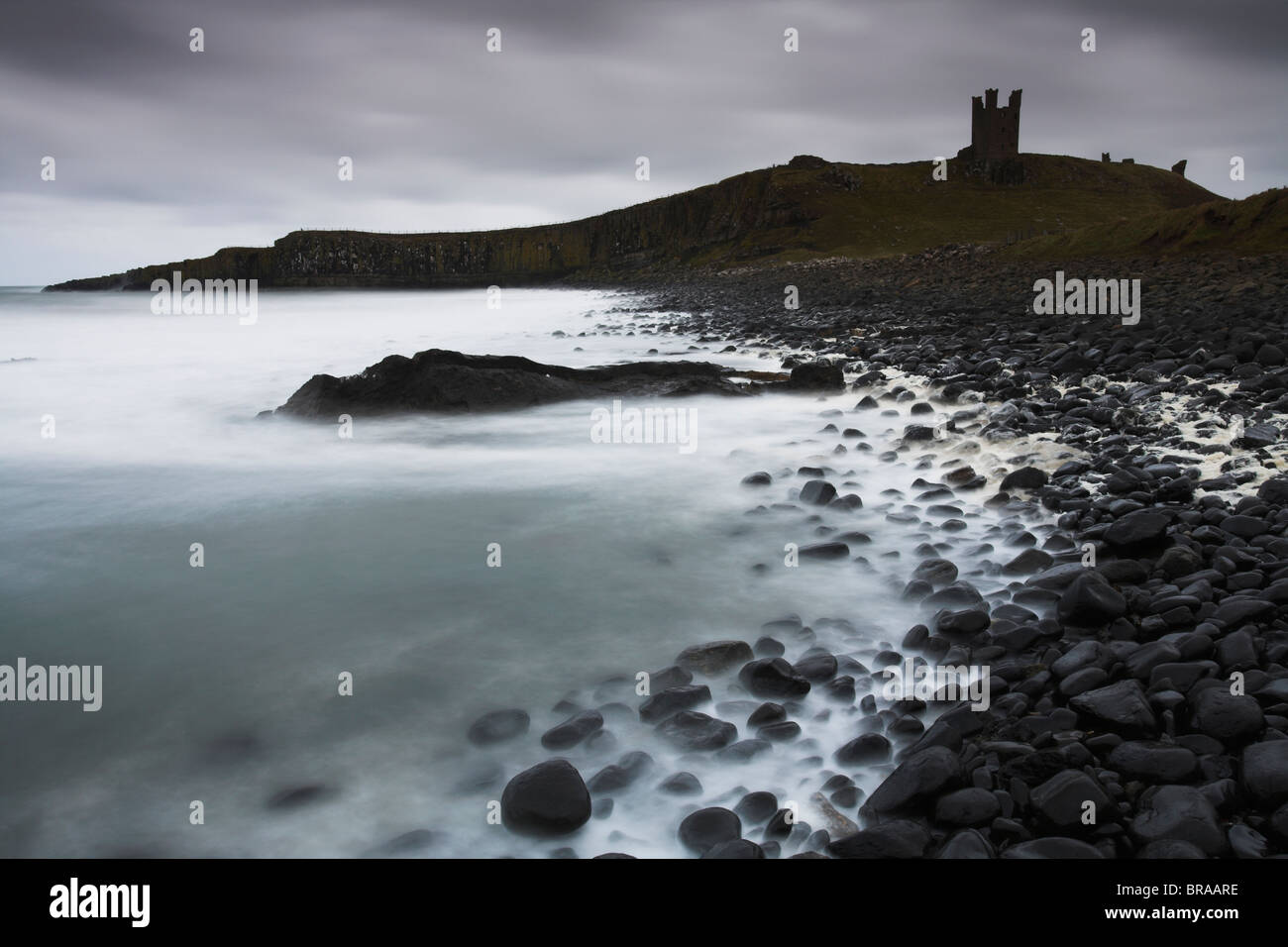 Château de Dunstanburgh sur un soir orageux, Northumberland, England Banque D'Images