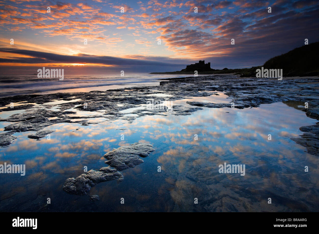 Lever du soleil sur le château de Bamburgh, Northumberland, Angleterre Banque D'Images