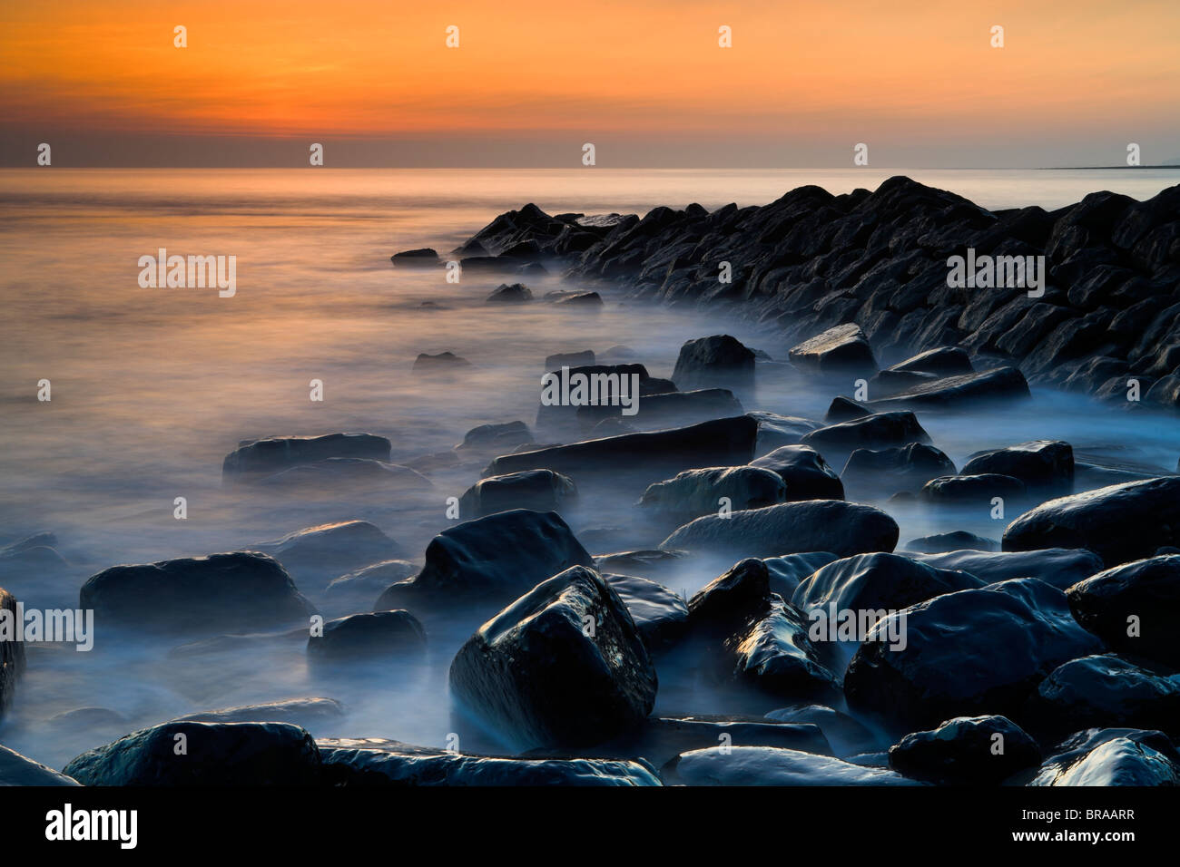 Misty eau tourbillonnant autour de roches humides à Kimmeridge Bay, Dorset, Angleterre. La Côte Jurassique, site du patrimoine mondial. Banque D'Images