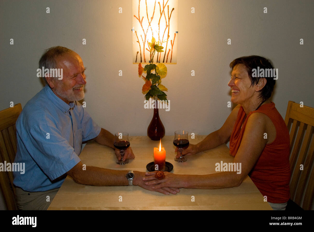 Couple de personnes âgées avec un verre de vin à la chandelle Banque D'Images