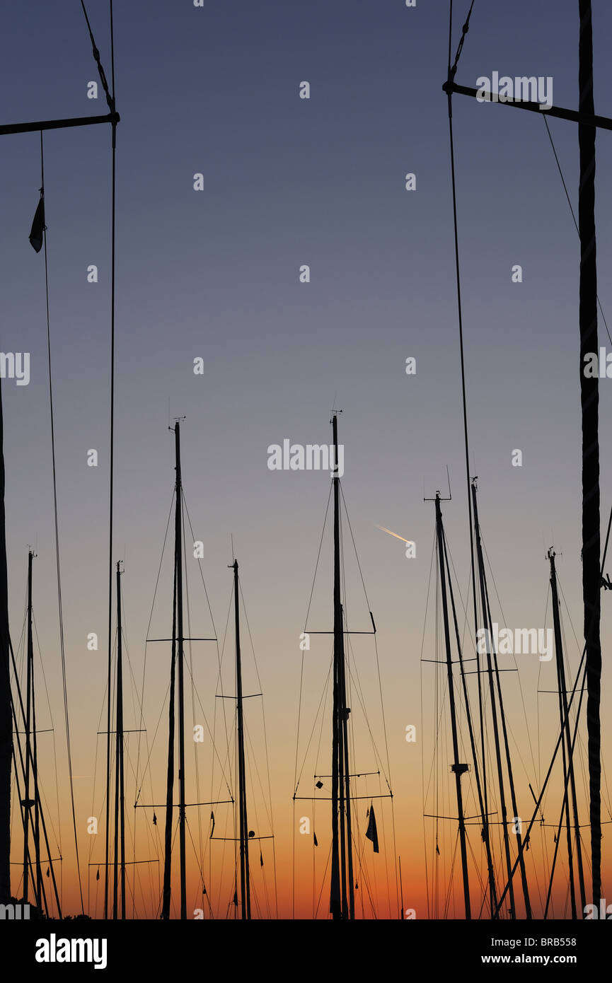 Bateau à voile mâts au coucher du soleil dans une marina Banque D'Images