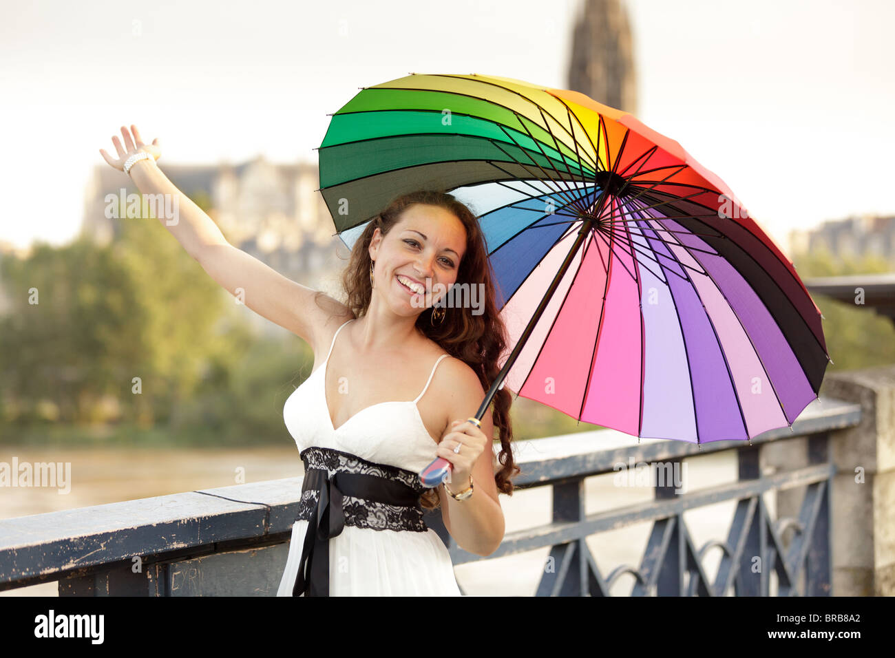 Femme française marche sur Rainbow bridge holding umbrella in Bordeaux, France Banque D'Images