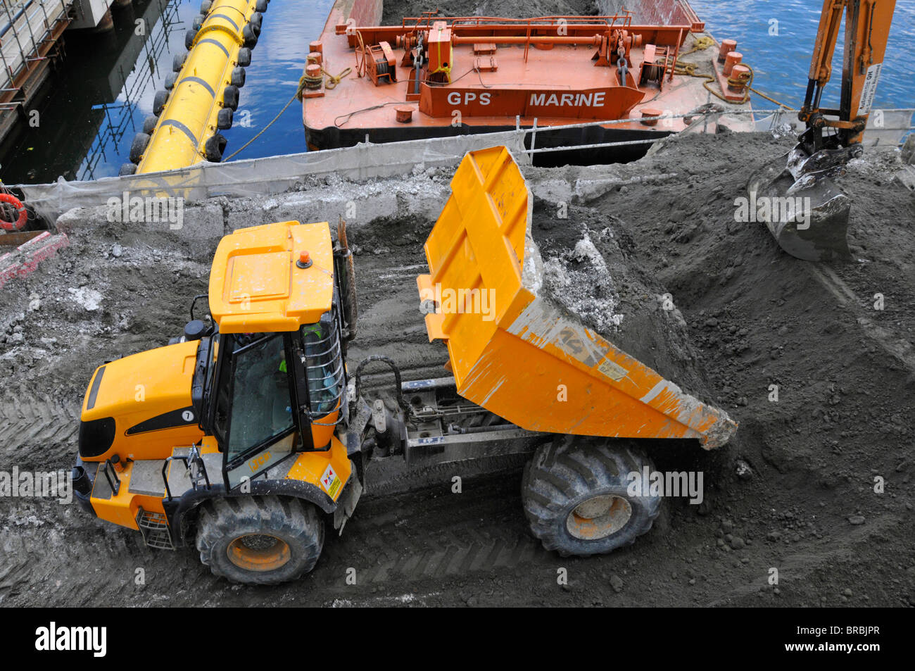 Vue aérienne construction chantier tombereau basculant la terre de la base creusant dans le tas de déblais pour que la pelle hydraulique se charge dans une barge Banque D'Images