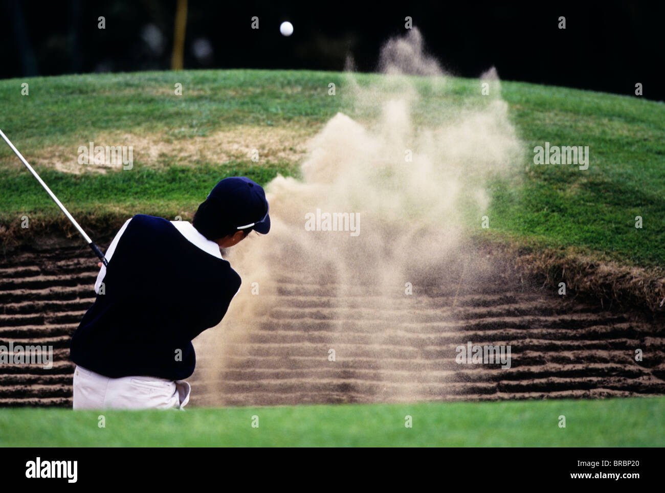 Explosions golfeur son ballon de bunker sur le green Banque D'Images