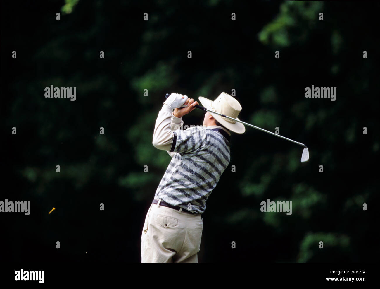 Golfeur en hat chasse tee avec fer à repasser Banque D'Images