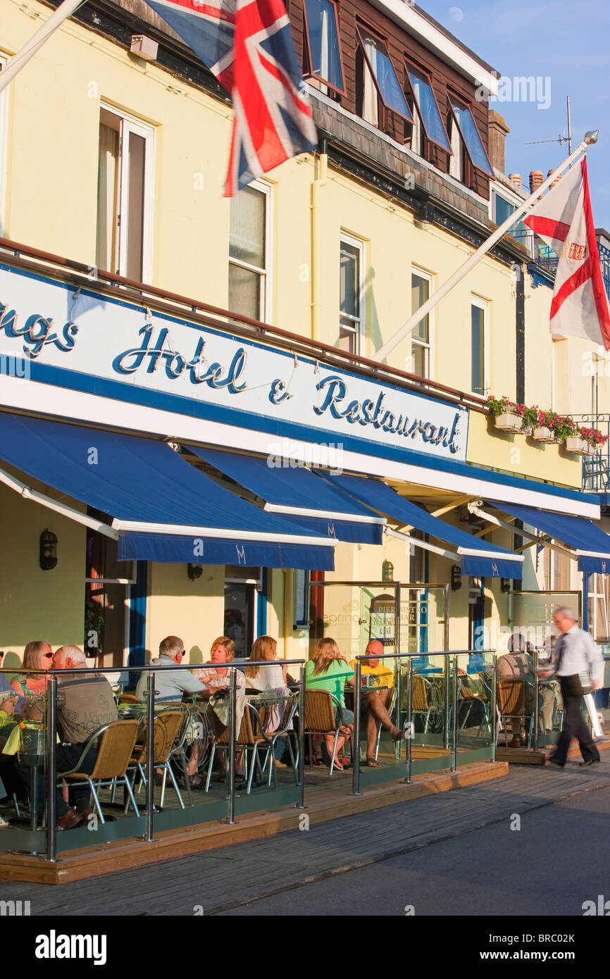 Les touristes assis à l'extérieur des restaurants et bars, Gorey harbour, Jersey, Channel Islands, Royaume-Uni Banque D'Images