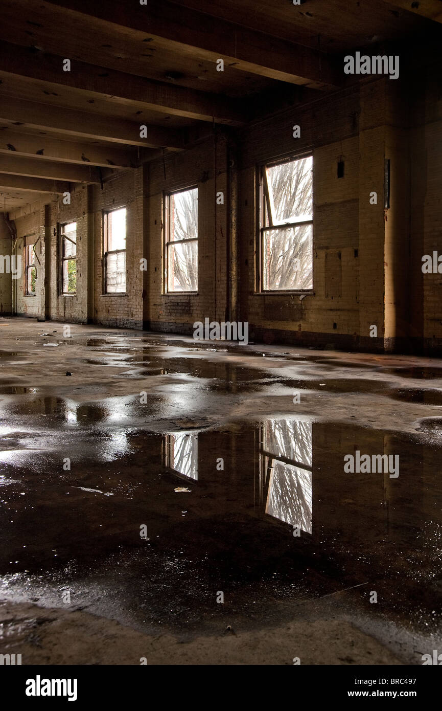 Ancien bâtiment industriel abandonné avec des flaques d'eau sur le plancher, Philadelphia, USA Banque D'Images