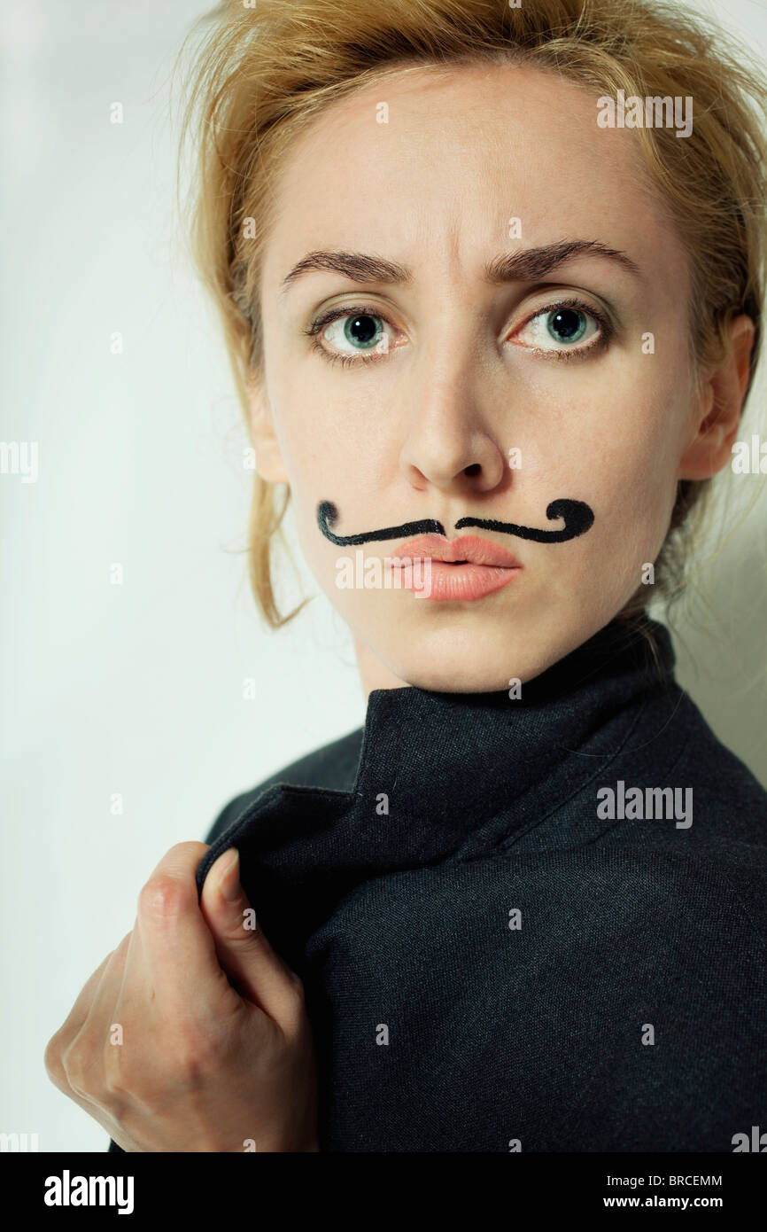 Belle jeune femme avec moustache peinte portant jacket Banque D'Images