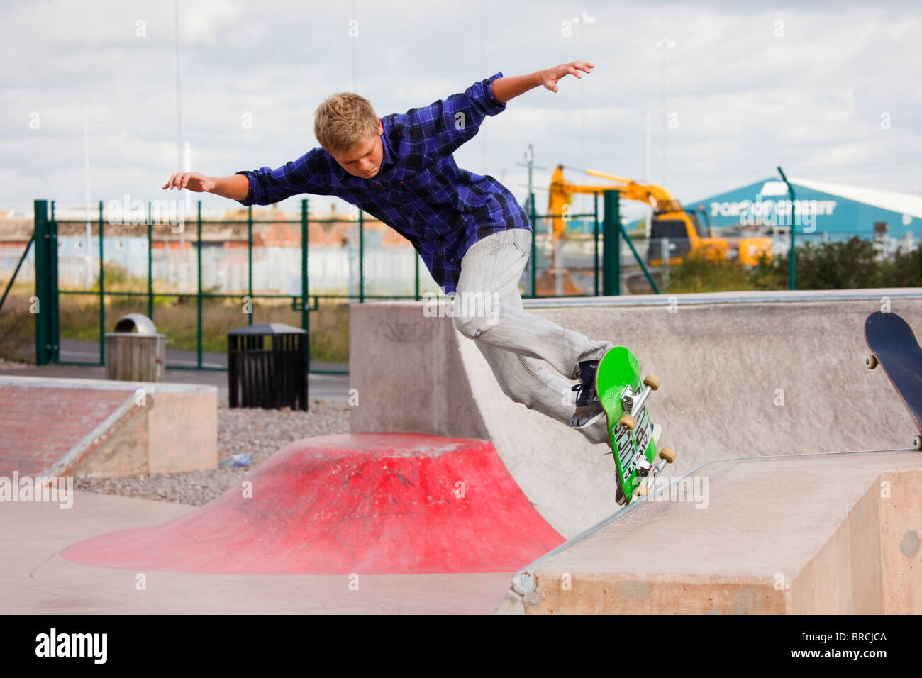 Teenage boy skateboarding en Skate Plaza nouveau parc de skate. Barrage de Cardiff Bay Park, Cardiff, Glamorgan, Pays de Galles, Royaume-Uni, Angleterre Banque D'Images
