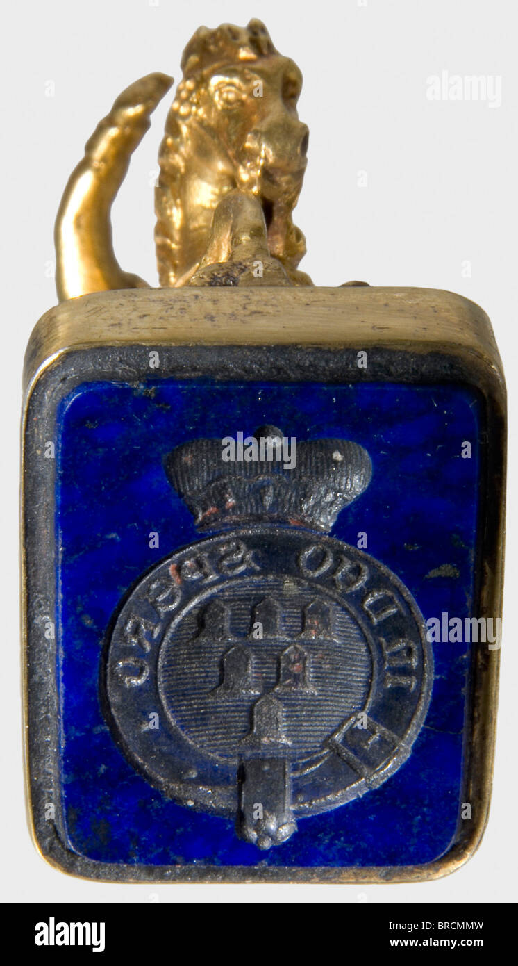 Reichsmarshal Carl Theodor Count Pappenheim (1771 - 1853), un sceau d'or en forme d'équitation, représentant l'empereur Napoléon Ier de France. Figure tridimensionnelle, l'empereur à cheval, portant un manteau et pointant vers l'avant avec sa main droite. 14 ct or, hauteur 42 mm. La base de Lapis lazuli est en argent doré et porte le manteau sculpté des bras des Comtes de Pappenheim avec la devise 'Dans Deo Spero' (j'espère en Dieu), surface de joint 16 x 22 mm. Avec la housse originale en cuir Maroc rouge avec doublure en velours/soie de couleur claire. Le joint était probablement un gif, Banque D'Images
