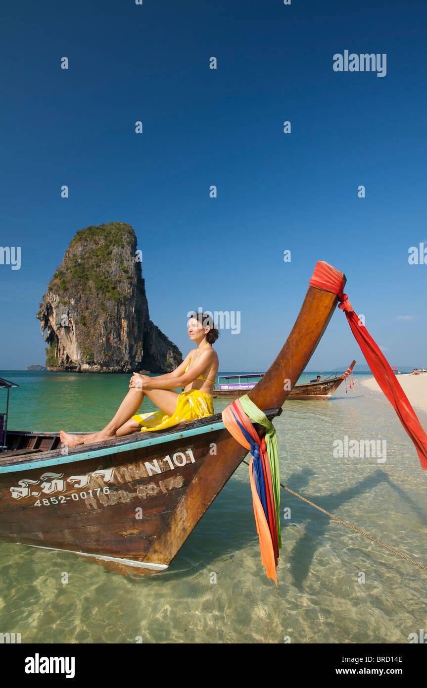 Femme se détendre sur un bateau à longue queue à Laem Phra Nang Beach, Krabi, Thaïlande Banque D'Images