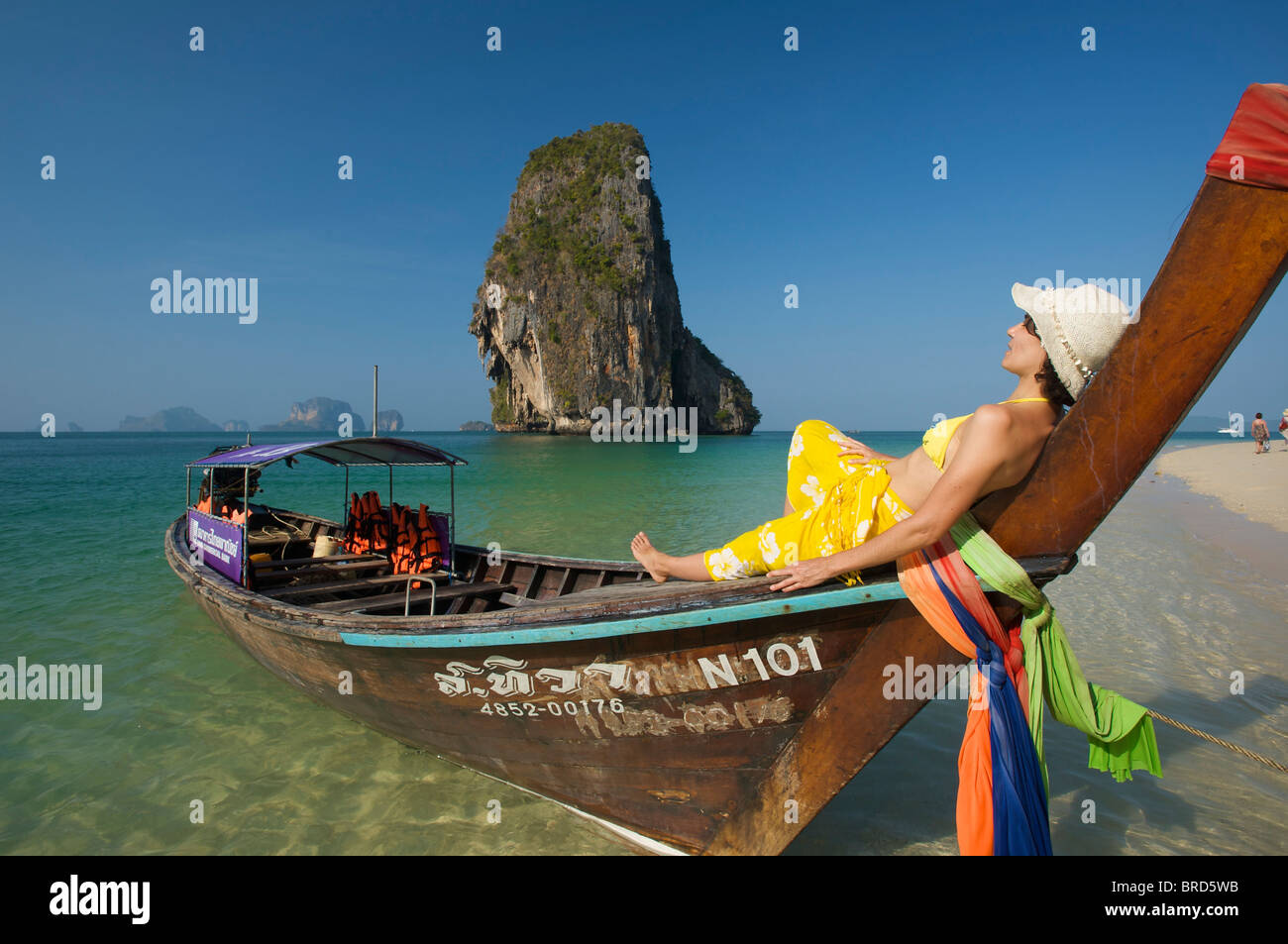 Femme se détendre sur un bateau à longue queue à Laem Phra Nang Beach, Krabi, Thaïlande Banque D'Images
