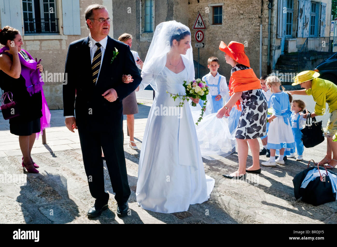 Mariée avec le père et les garçons et les filles page holding suite nuptiale train - France. Banque D'Images