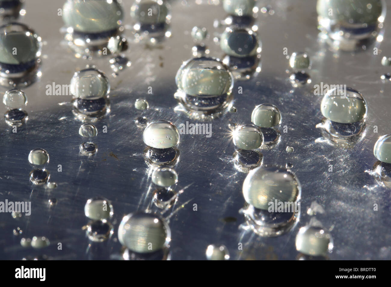 Goutte d'eau sur une surface en verre ciré (miroir) Banque D'Images