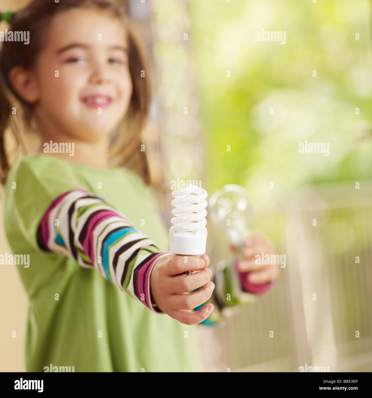 Girl holding ampoule et souriant. Selective focus, copy space Banque D'Images
