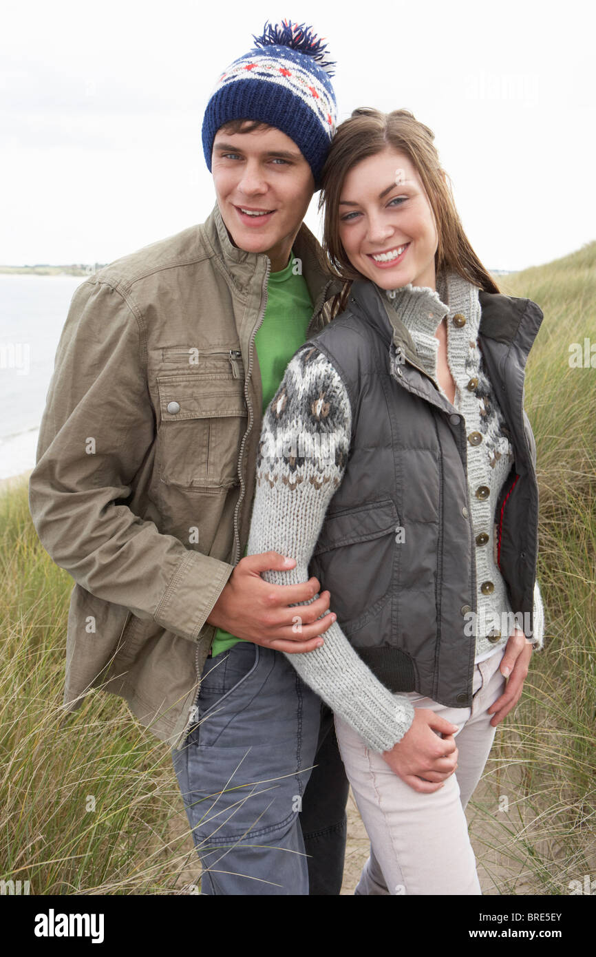 Jeune couple en train de marcher à travers les dunes de sable portant des vêtements chauds Banque D'Images