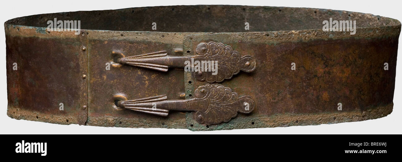 Une ceinture italique, 4ème siècle avant J.-C. fermée, ceinture en bronze non décorée avec une rangée de trous et impression de la doublure le long du périmètre . Deux crochets de fixation rivetés en forme de paumes. La courroie a été réparée ou allongée près de la troisième rangée de trous de fixation. Longueur 84 cm. Crochets 10 cm. Largeur 6,8 cm. Patine rougeâtre brun à vert montrant la surface métallique dans les endroits. Cf. Londres Christie, vente aux enchères 6 novembre 2002, lot 76. Collection Axel Guttmann (R 113/AG 409 c). Acquis à Paris en 1991. Ceinture de bataille simple, très bien préservée, qui était portée sous la feuille, Banque D'Images