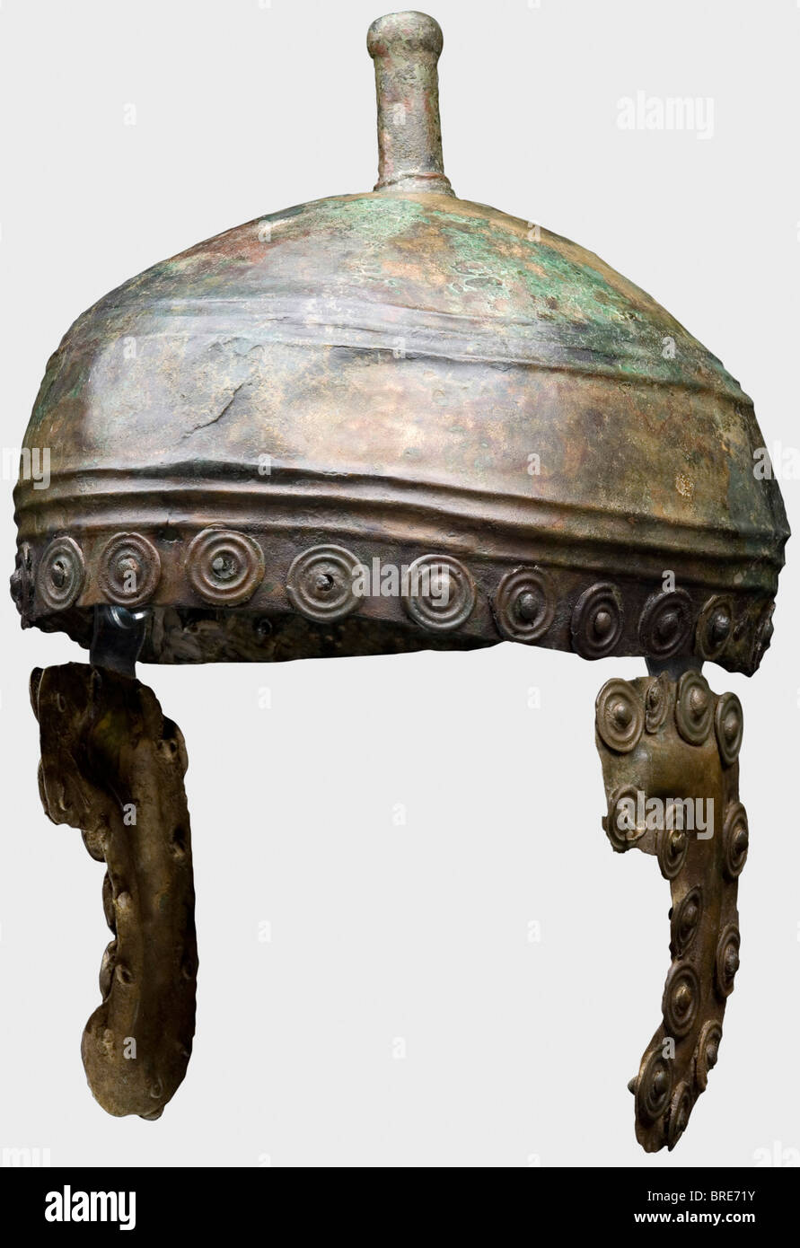 Un casque d'âge de bronze, crâne De bronze Peu Profond de la Colombie-Britannique du XIIIe et du XIIe siècle avec deux bandes de trois crêtes et un pommeau de casque moulé avec une ouverture cylindrique pour l'écusson du casque. Morceaux de joue incurvés, précédemment fixés à la doublure du casque. Disques décoratifs rivés autour du périmètre du casque et des pièces à joues. Hauteur totale 16,5 cm. Poids 483 g. En outre, des fixations décoratives, deux bracelets et une tête de flèche. Le métal est bien conservé avec une patine verte dans les endroits, et des résidus organiques et de saleté. Légèrement déformée. Fissuré d'un côté. La stabilisation intérieure, Banque D'Images
