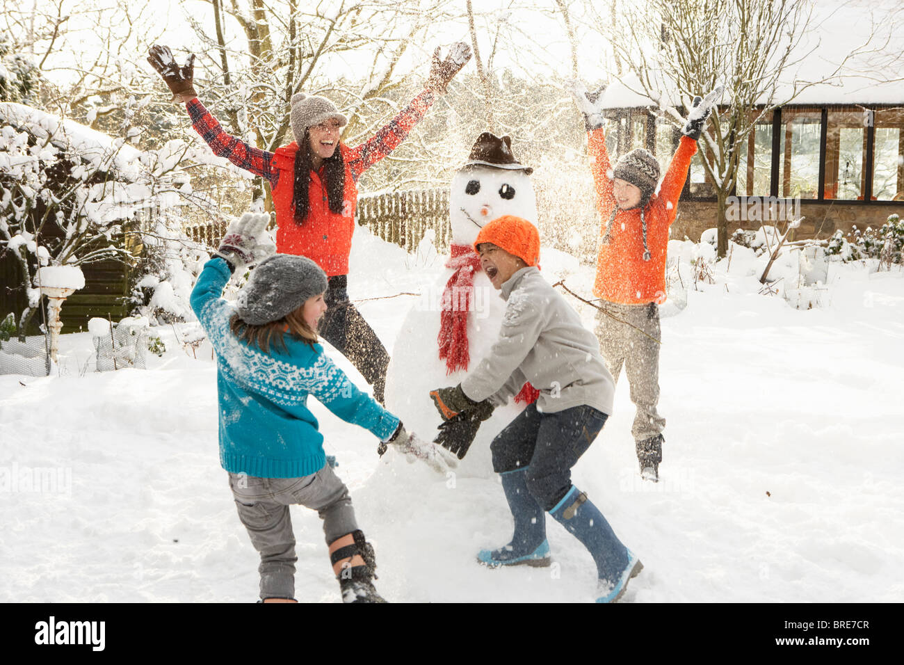 Mère et enfants en jardin Bâtiment Snowman Banque D'Images