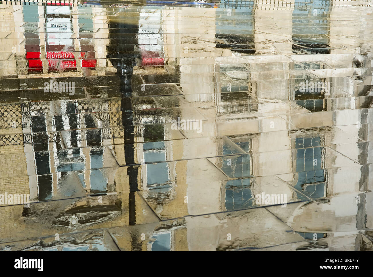 Reflète les bâtiments sur le trottoir après une brève douche à Londres, Angleterre, Royaume-Uni. Banque D'Images