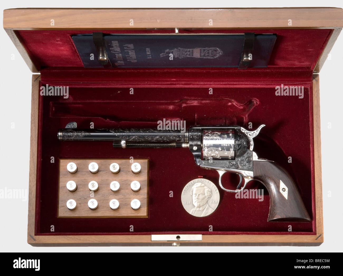 Un Colt SAA « modèle esquicentennal », Un des 50, cal..45 LC, no 2 100 SC. Alésage brillant, longueur 7 1/2', fabricant, modèle et calibre marqués sur la surface supérieure gauche et droite. Quatre anneaux incrustés d'or blanc. Cylindre, protection de déclenchement et cadre de poignée plaqué argent. En bas de la signature de télécopie de GRIP Samuel Colt. Toutes les pièces avec gravure de vigne fine. Empiècements en bois sombre tropical. Livré avec un boîtier en bois incrusté de velours rouge. L'étui contient douze cartouches factices, une médaille en l'honneur du sesquicentenvial de Samuel Colt ainsi que le livre « The Arms Collection of Colon, Banque D'Images