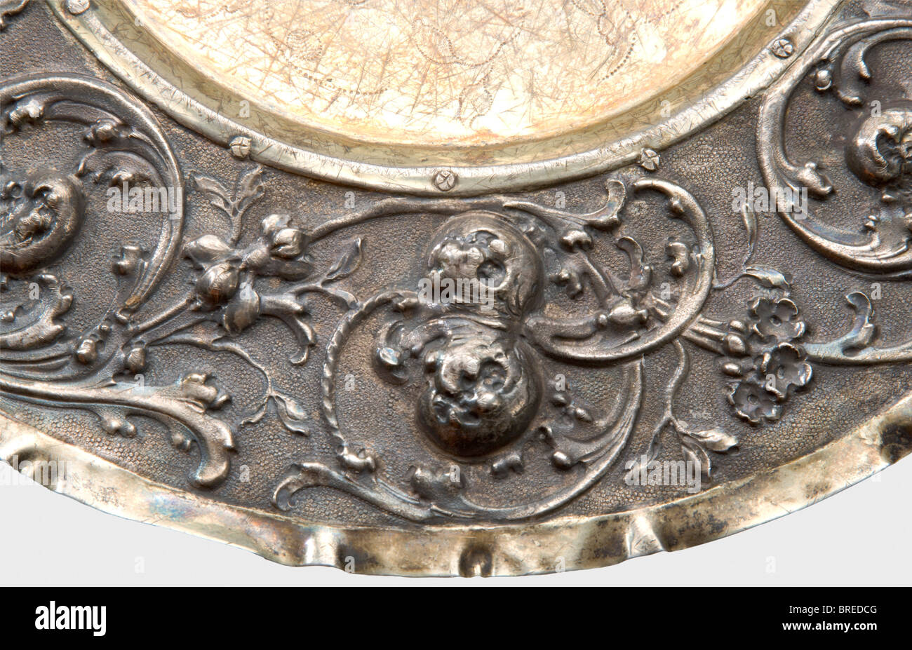 Une plaque d'affichage d'Augsbourg, Peter Rams, vers 1690 argent, partiellement doré, avec une décoration florale gravée en relief sur un fond pourchassé. Centre doré riveté. La marque principale, 'PR' et la marque de pin d'Augsbourg sont sur le côté. Diamètre 27,5 cm. Poids 287 g. Une ancienne étiquette d'inventaire cyrillique à peine lisible sur le fond 'No.135...' ainsi que les étiquettes d'inventaire 'ON' et 'H.V.W.' G.v.R.'. Probablement un cadeau familial à la Grande duchesse Olga de la collection d'art de Romanov. Provenance Grand Duchesse Olga Nikolaevna Romanova (1822 - 1892). Historique, Historique, Banque D'Images