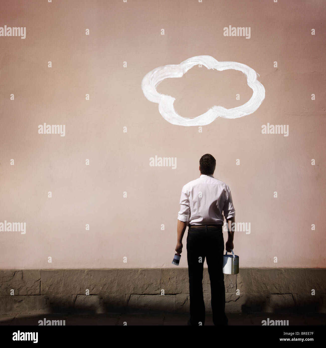 Avec l'homme sur le mur peint de nuages Banque D'Images