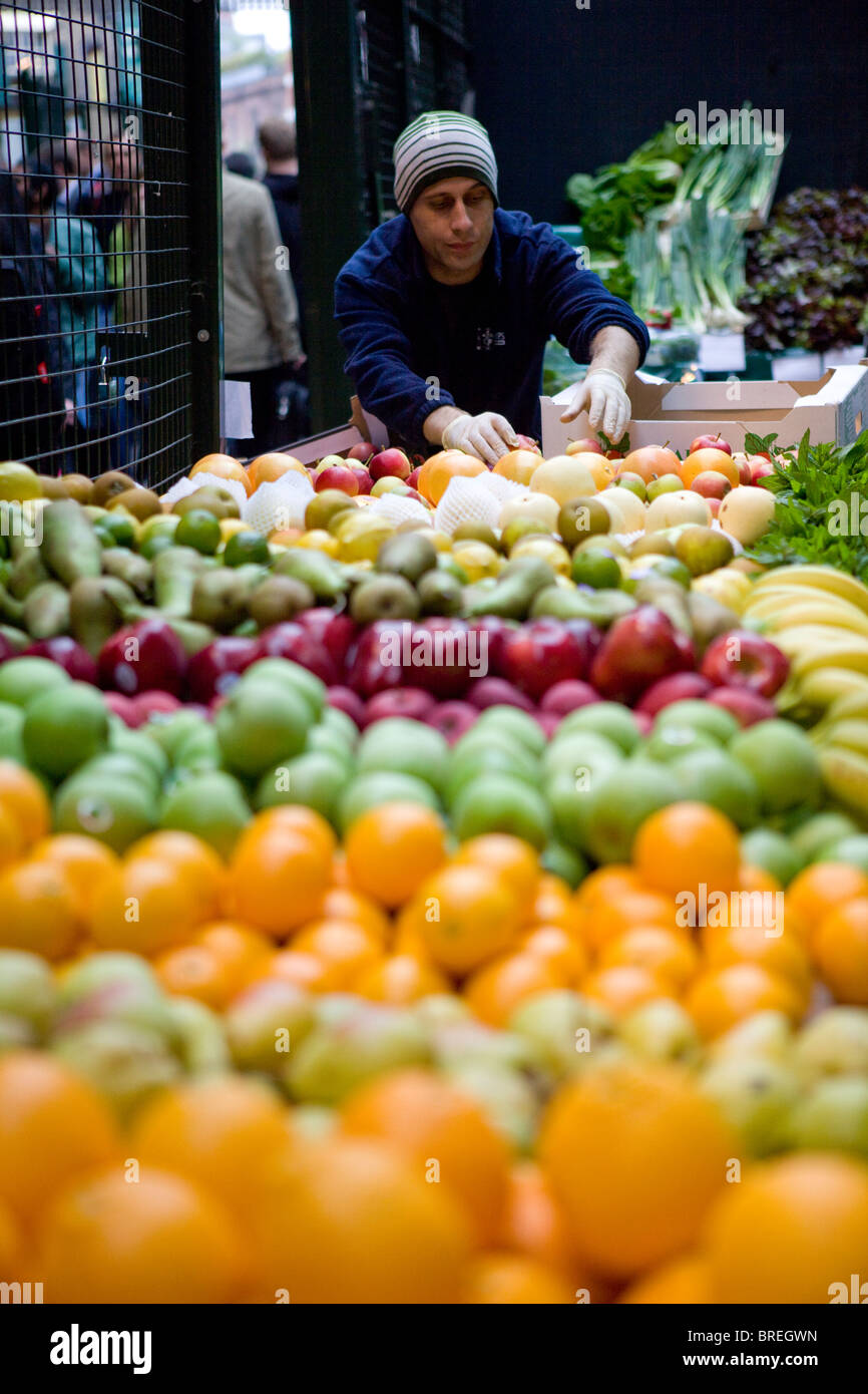 Opérateur de marché vend des fruits et légumes à Borough Market Banque D'Images