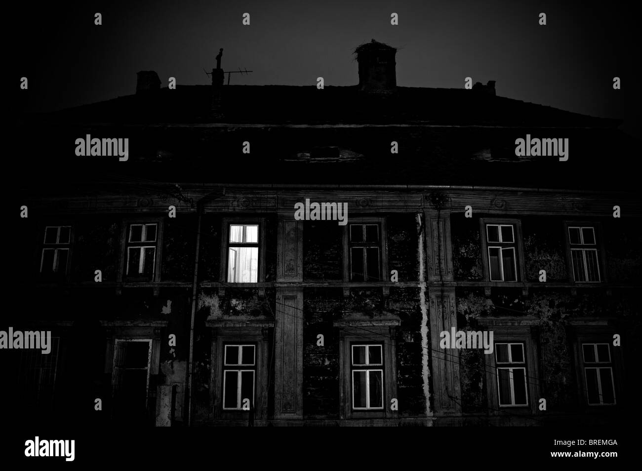 Roumanie, Sibiu. La lumière d'une fenêtre d'une ancienne maison la nuit Banque D'Images