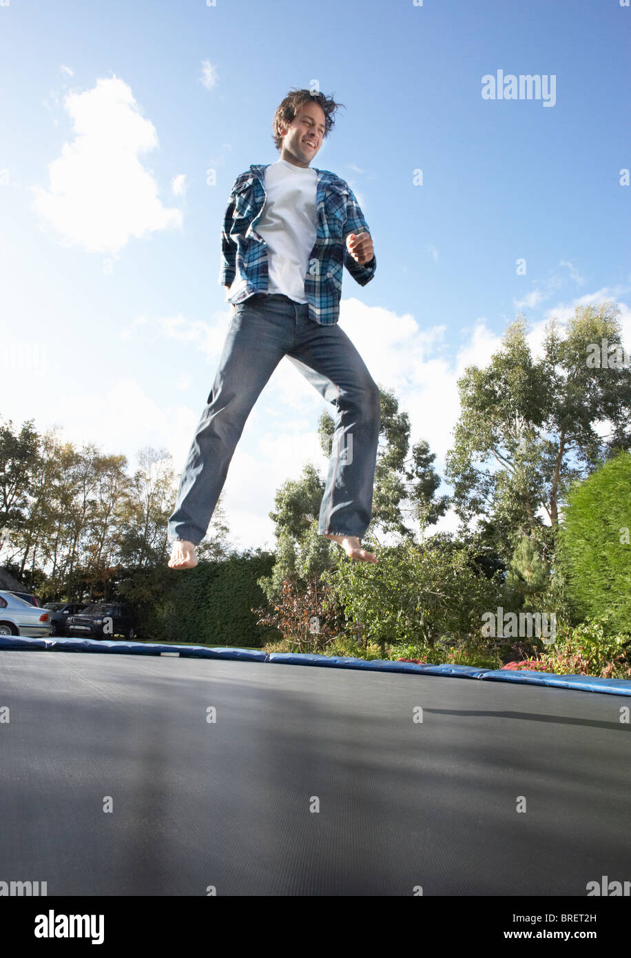 Jeune homme saut sur trampoline pris dans les airs Photo Stock - Alamy