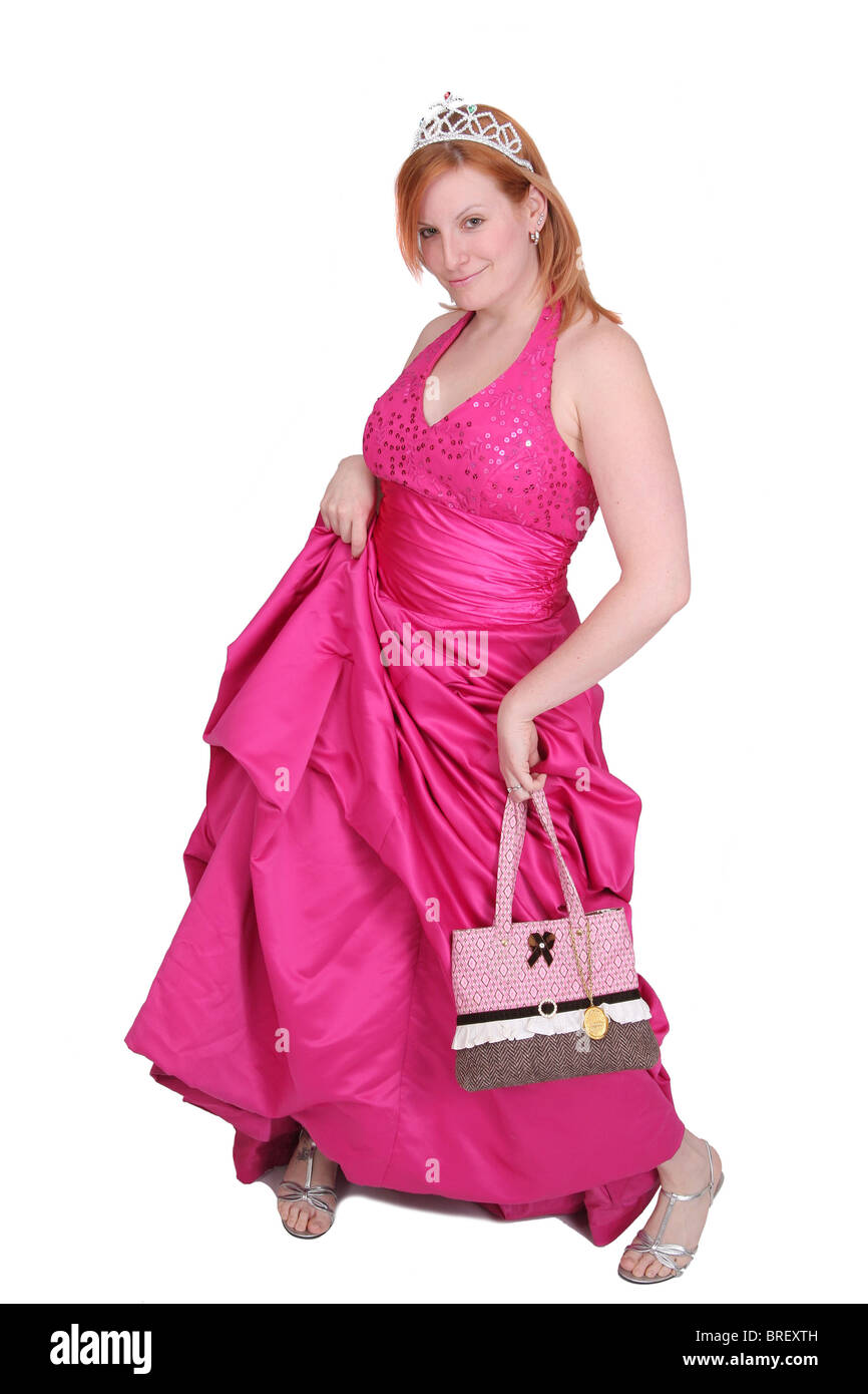 Une vingtaine redhaired femme dans une robe de bal rose sur fond blanc type Banque D'Images