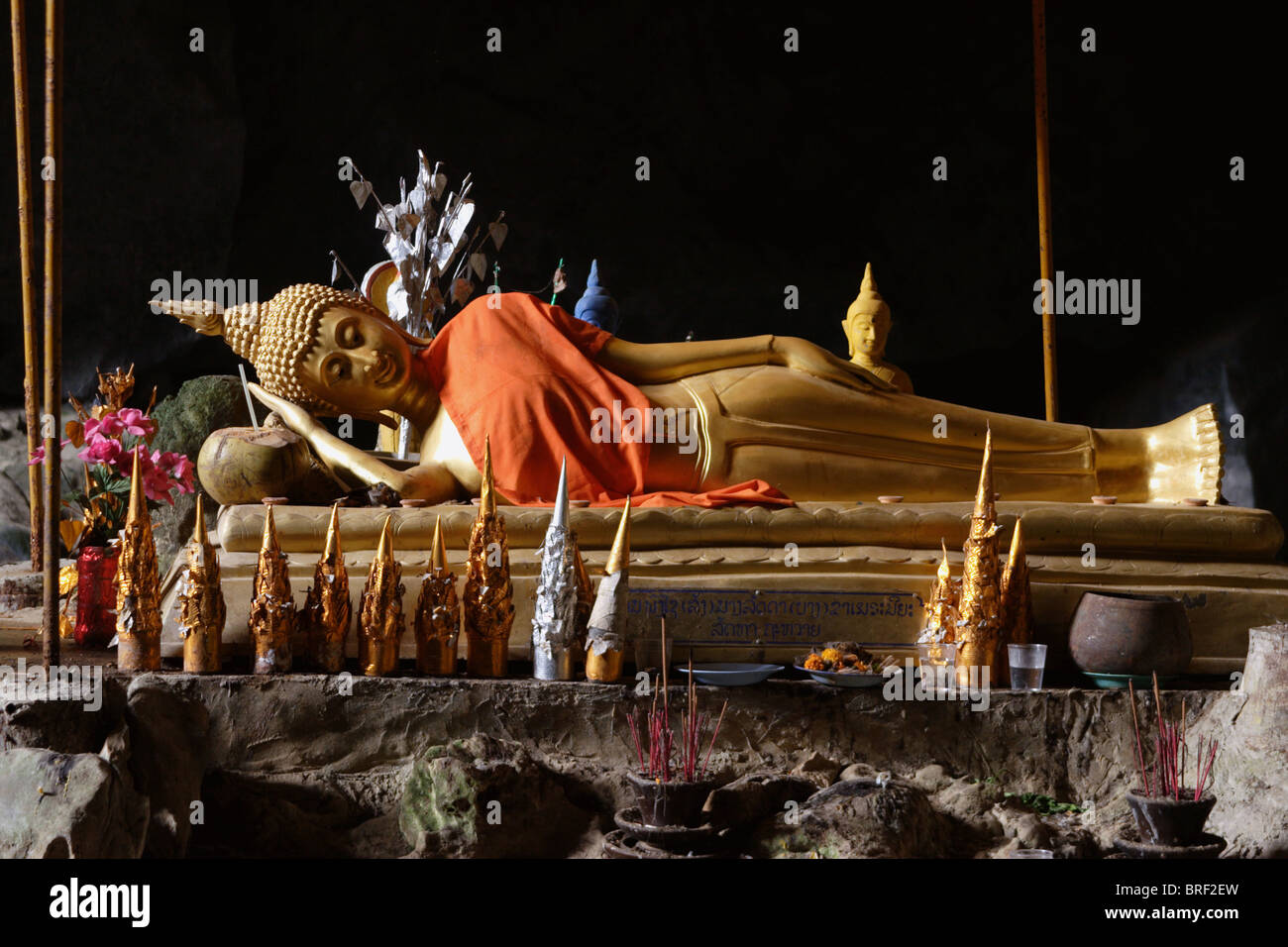 Un Bouddha couché repose dans l'après-midi du soleil dans une grotte près de Vang Vieng, Laos. Banque D'Images