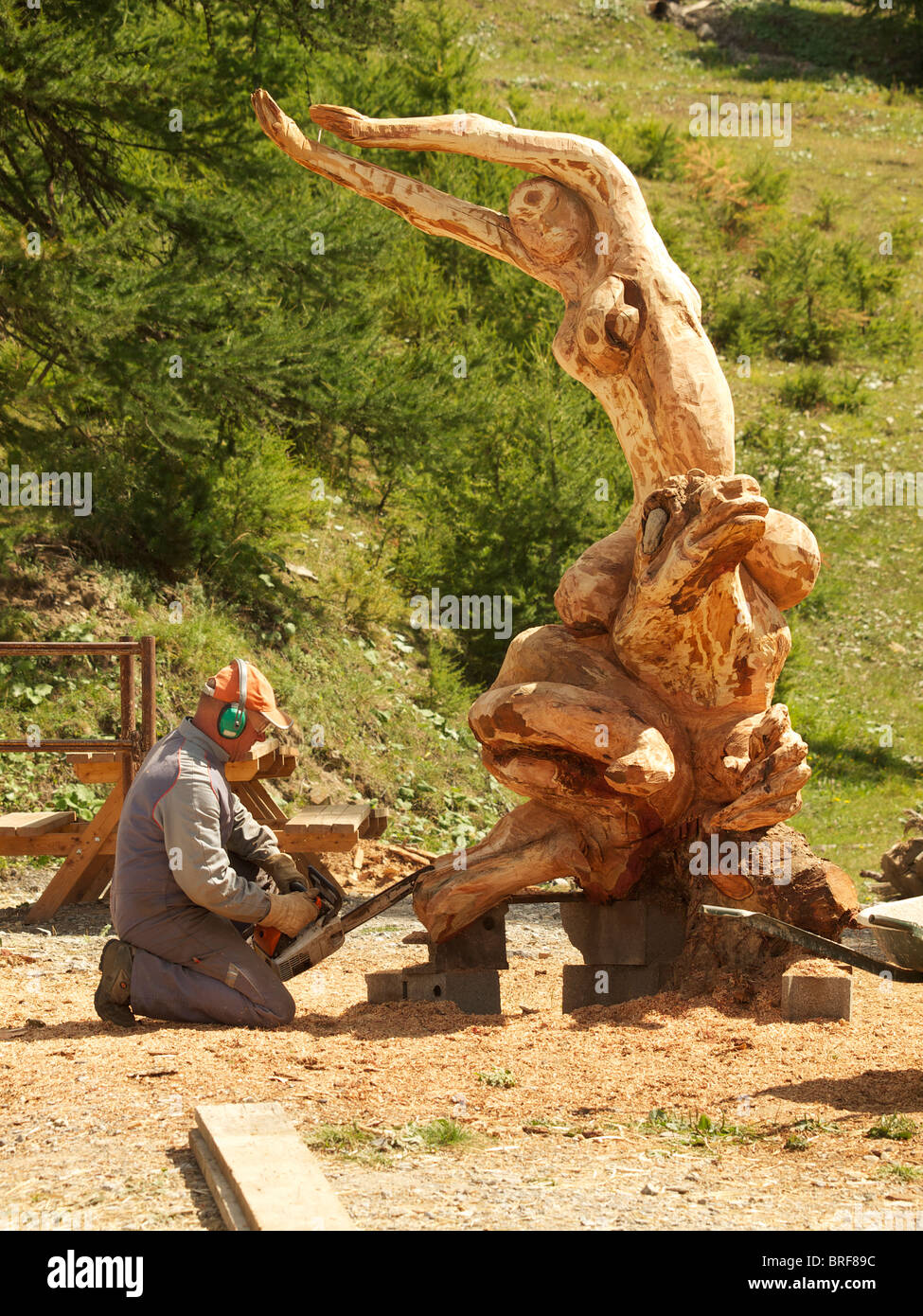 Artiste sculpteur la création d'une sculpture en bois à l'aide d'une tronçonneuse dans Les Orres, Hautes Alpes, France Banque D'Images