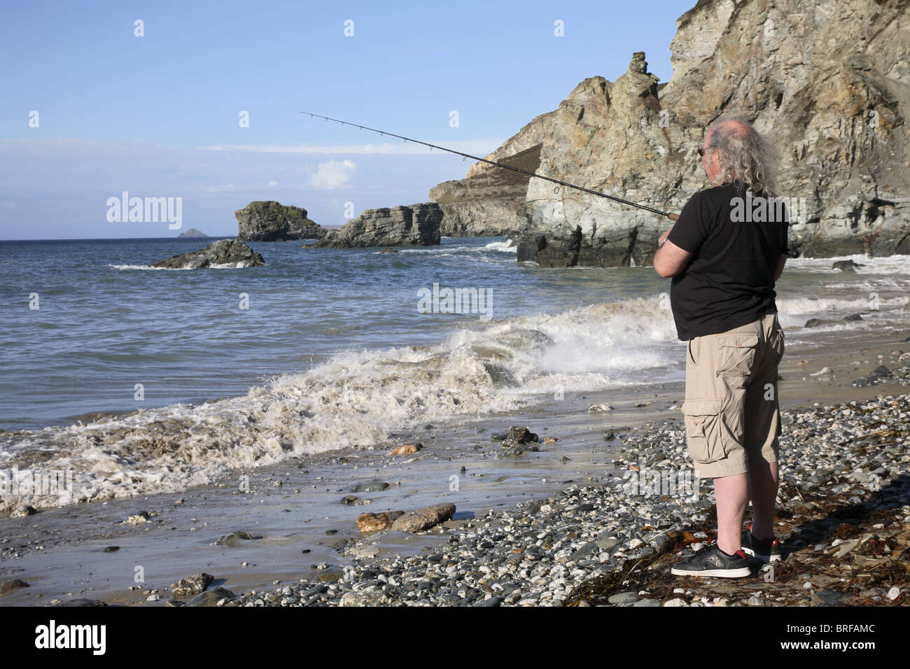 L'homme pêche en mer dans la région de Cornwall, UK. Banque D'Images