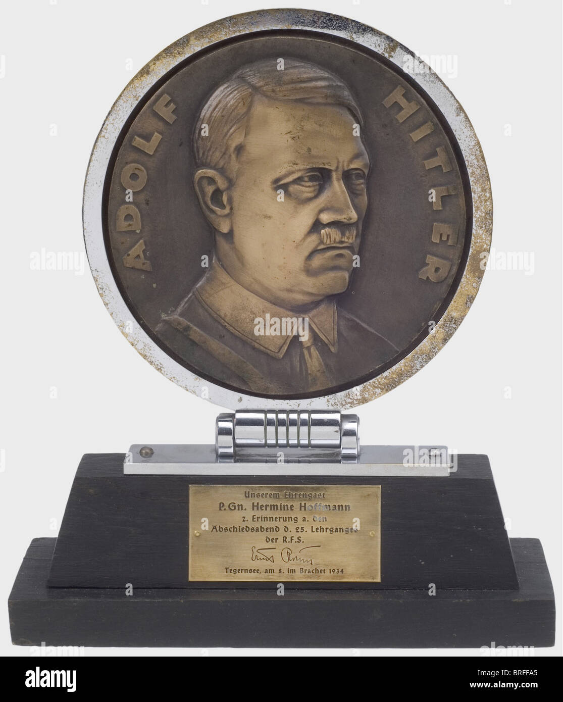 Hermine Hoffmann - cadeau commémoratif présenté par Ernst Röhm en 1934. Grande plaque ronde en bronze portant le portrait d'Adolf Hitler en uniforme de parti, avec bord nickelé et charnière sur le côté inférieur, Monté sur une base en bois étagé avec étiquette en laiton gravé sur le devant de la lecture (transl.) 'À notre invité d'honneur, membre du parti Hermine Hoffmann, en souvenir du dîner d'adieu tenu au 25ème cours de formation de la R.F.S. - Ernst Röhm - Lac Tegern, 8 Juin 1934'. Le bord de la plaque en relief « A. Rettenmaier Gmünd' en marche arrière. À, Banque D'Images