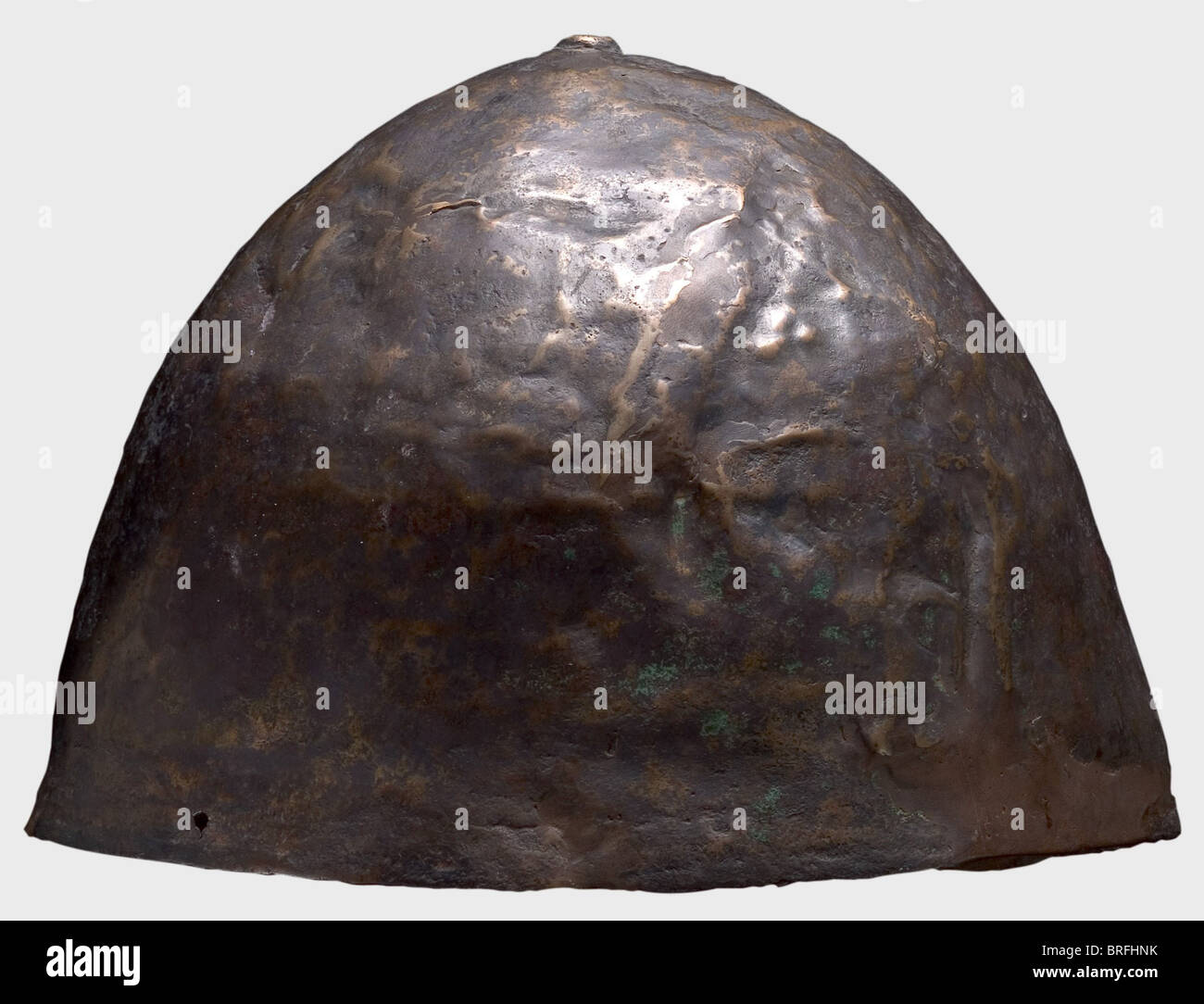Un casque proche de l'est, 1ère moitié du 1er millénaire B.C.le crâne est en bronze avec un grand pourcentage de cuivre.il est relativement peu profond, fortement bombé, et relativement mince-côté.le haut du casque est couronné d'un bouton plat en relief.UN petit trou au bord du casque vraisemblablement servi pour fixer le Mentonnière.hauteur 15.7 cm.poids 583 g.le métal est bien conservé, légèrement déformé, et a une patine noire brunâtre.après sa récupération, il a été ramené à sa forme originale et a donné une patine légère.Petites restaurations dans le crâne, droits additionnels-Clearences-non disponible Banque D'Images