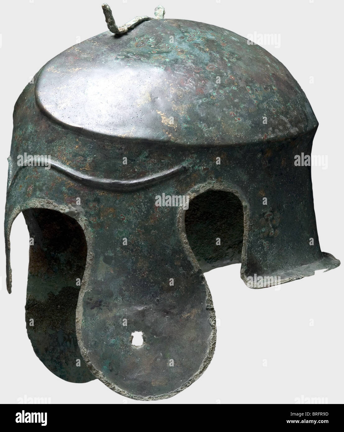 Casque Chalcidien, 5e siècle B.C.Bronze. Crâne allongé étroit avec couronne sculptée et crêtée, fixation en forme de fourche pour le panache du casque, grandes pièces de joue lobé et découpes d'oreilles, et une protection de cou à évasement court. Le front avec de longs sourcils décoratifs en relief. Le rebord du casque a conservé une partie du bord soudé (brasure en brasure Placez tout autour). La joue gauche est courbée vers l'extérieur avec une perforation sévère, probablement à partir de l'offre votive du casque dans un sanctuaire.hauteur 19.5 cm.poids 638 g.le métal est bien-pr, droits supplémentaires-Clearences-non disponible Banque D'Images