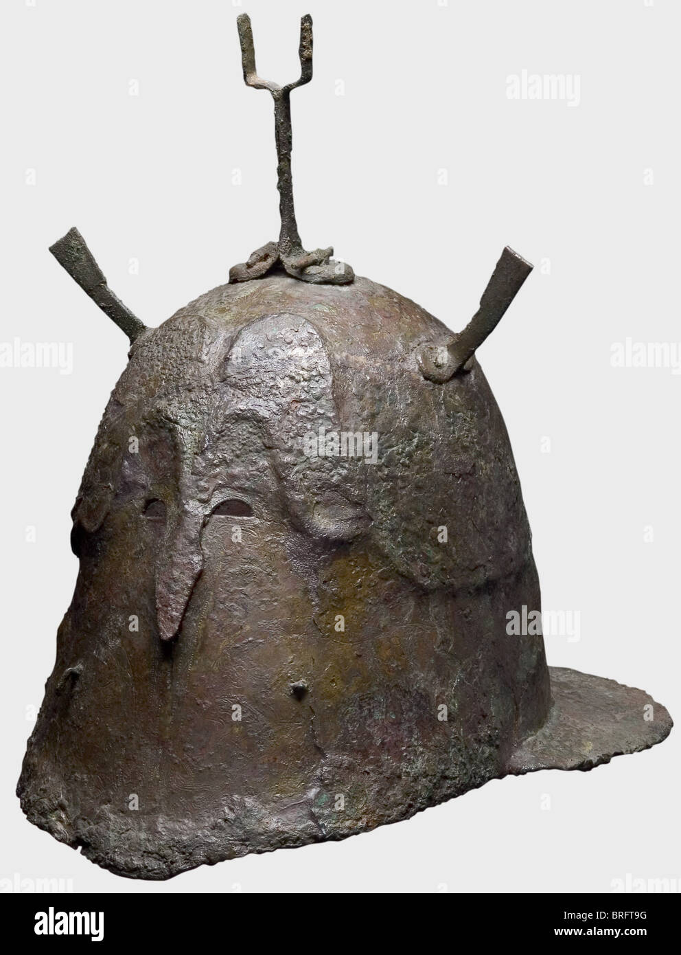 Un casque Apulian-Corinthian, 5e siècle B.C.A grand, lourd, prolongé en bronze. Deux petits crochets sur les plaques de joue complètement fermées, au centre une ligne de séparation d'imitation pontée. Petits découpes d'oeil, et un protubérant, stridé nasal.vestiges de nombreuses gravures décoratives de sangliers et de grands chats.lignes ornementales affichant des points de poissons et des splets.ainsi QUE de petits motifs métaltés Fourche de panache sur le dessus du dôme ainsi que deux supports rivetés montés sur le côté et un anneau sur le bord du col. Hauteur avec fourche de panache 30.2 cm. Longueur 32.7 ,droits supplémentaires-Clearences-non disponible Banque D'Images