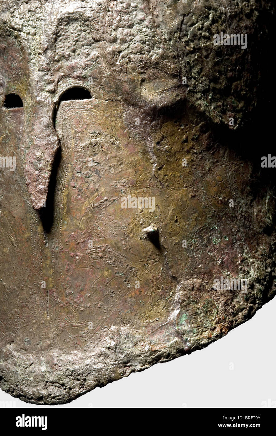 Un casque Apulian-Corinthian, 5e siècle B.C.A grand, lourd, prolongé en bronze. Deux petits crochets sur les plaques de joue complètement fermées, au centre une ligne de séparation d'imitation pontée. Petits découpes d'oeil, et un protubérant, stridé nasal.vestiges de nombreuses gravures décoratives de sangliers et de grands chats.lignes ornementales affichant des points de poissons et des splets.ainsi QUE de petits motifs métaltés Fourche de panache sur le dessus du dôme ainsi que deux supports rivetés montés sur le côté et un anneau sur le bord du col. Hauteur avec fourche de panache 30.2 cm. Longueur 32.7 ,droits supplémentaires-Clearences-non disponible Banque D'Images