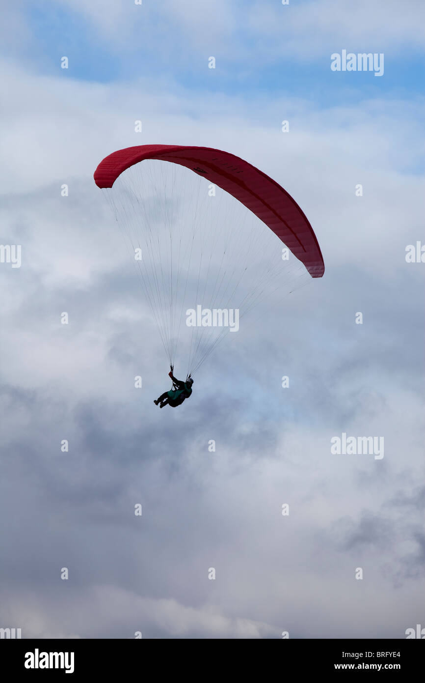 Une personne est suspendue à un parachute parapente-like et flotte dans l'air au-dessus de Abergavenny, Monmouthshire, Galles du Sud. Banque D'Images